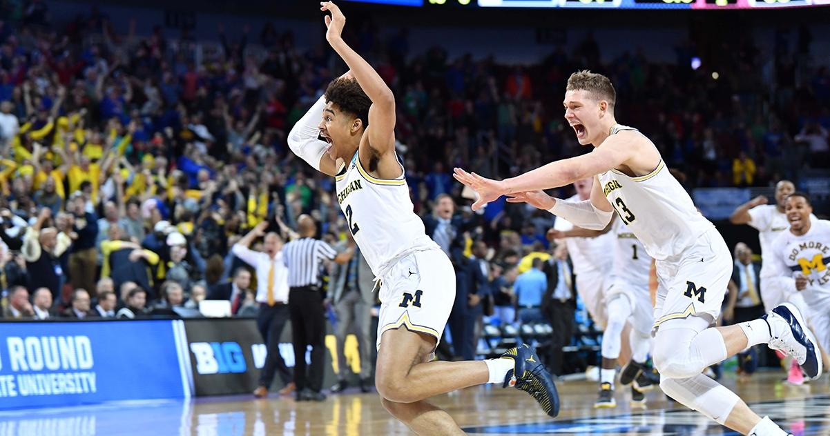 Michigan's Jordan Poole runs from Mortiz Wagner.